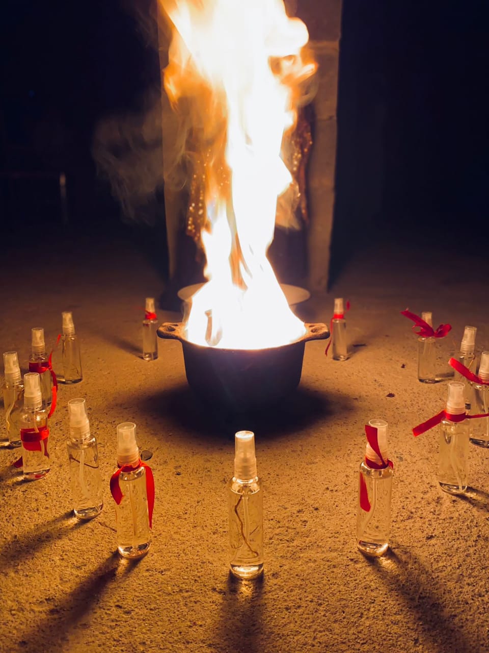 Frascos dispostos em círculo ao redor da fogueira ritual durante a consagração.